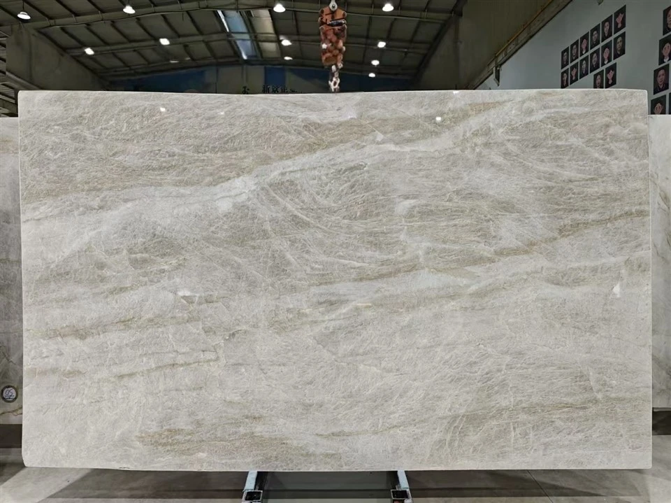 Full Taj Mahal Quartzite slab with a honed finish, warm off-white background and layered gray-beige natural movement.